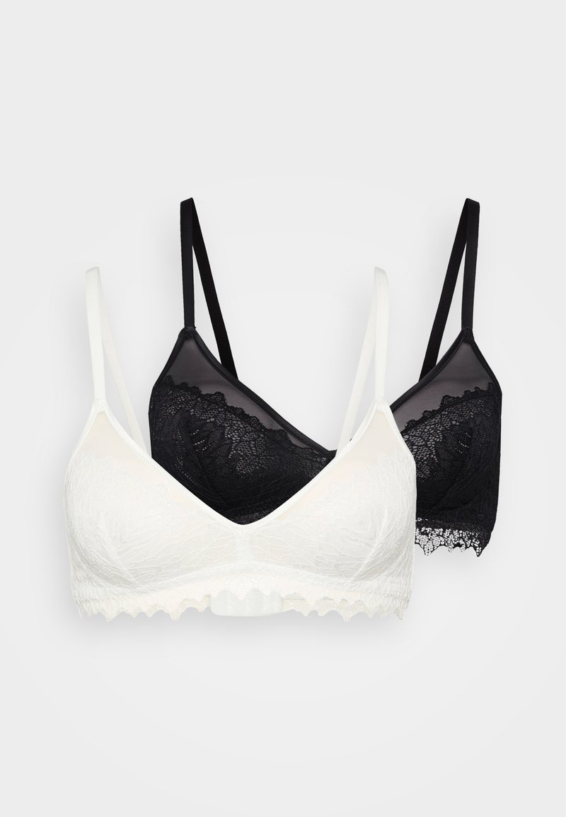 Deux bralettes : l'une en blanc avec une texture en dentelle florale et des bords festonnés, l'autre en dentelle noire avec des bretelles réglables.
