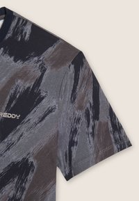 T-shirt in cotone con un motivo astratto a pennellate grigio scuro e beige, scollo rotondo, maniche corte e un piccolo logo metallico.