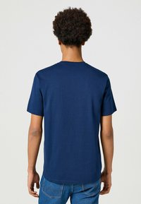 Marineblå bomulds T-shirt med korte ærmer, rund hals og en glat tekstur, vist fra ryggen med en afslappet pasform.