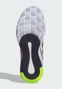 Semelle de chaussure avec une surface blanche texturée, présentant un motif en grille, une semelle intermédiaire gris foncé et un accent vert vif au niveau du talon.