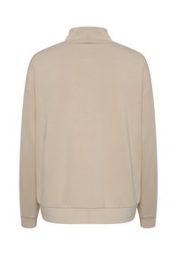 Pull beige à col montant, manches longues et ourlet côtelé. Texture lisse avec une coupe décontractée, sans motifs ni accents visibles.