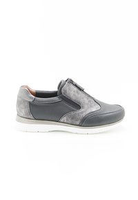 Zapato gris de cuero tipo slip-on con un frente texturizado, acentos plateados y cierre de cremallera. Suela de goma con un borde blanco en contraste.