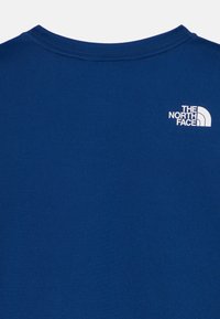 T-shirt azul-marinho com gola redonda, apresentando um logótipo branco da The North Face no lado superior esquerdo. Textura de tecido suave, design minimalista.
