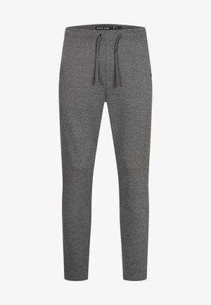 Pantalones deportivos grises con cintura de cordón ajustable, diseño de pierna cónica, textura suave y detalle de logotipo cerca de la parte inferior de la pierna izquierda.