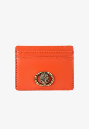 Porte-cartes en cuir orange avec quatre emplacements, texture lisse et un fermoir décoratif en ton doré présentant un embellissement détaillé.