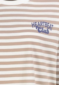 Gestreiftes T-Shirt aus beige-weißem Baumwollstoff mit rundem Halsausschnitt und blauer "HEARTBEAT Club"-Stickerei auf der Brust.