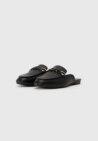 Black leather mules with a pointed toe, featuring a decorative chain and gold accents on the upper. Flat sole with a smooth texture.