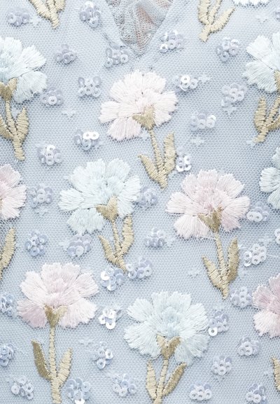 Ljusblått tyg med blomsterbroderi som visar rosa och ljusblå blommor. Paljetter framhäver designen. Texturerad bakgrund med nätmönster.