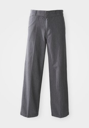 Harmaat pinstripe-tyyliset leveälahkeiset housut, joissa on vyölenkit, litteä etuosa ja suorat lahkeet, esitetty valkoista taustaa vasten.