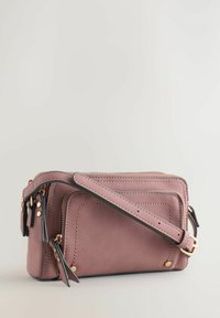 Bolso pequeño rectangular de cuero rosa apagado con herrajes dorados, compartimentos con cierre de doble cremallera y una correa desmontable. Textura suave.
