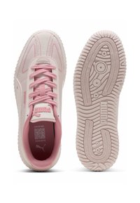 Sneaker Puma di un rosa chiaro con lacci abbinati, che mostrano una suola in gomma testurizzata e un codice QR sulla soletta per ulteriori informazioni.