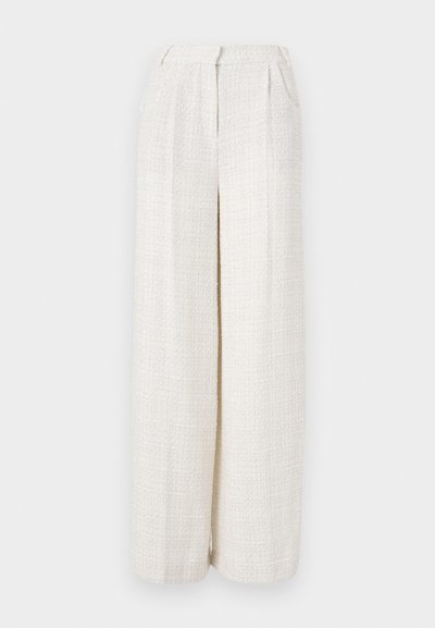 Pantalons larges en tissu beige clair avec un motif tissé texturé. Présentent une taille frontale et pas de fermetures visibles.