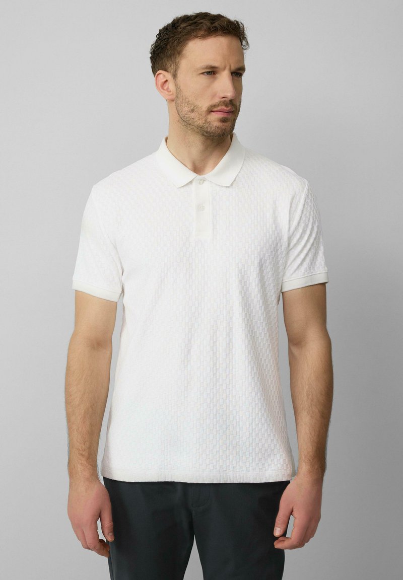 Witte poloshirt met een gestructureerd patroon, korte mouwen en een klassieke kraag. Gemaakt van een lichtgewicht stof. Geen zichtbare logo's of accenten.