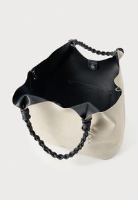 Beige shopper met zwarte gevlochten handvatten, open bovenkant met zwarte binnenvoering en een drukknoopsluiting.