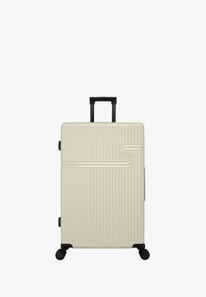 Hard-shell suitcase in beige with vertical grooves, retractable black handle, and four black wheels for easy mobility.