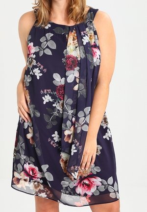 Vestido floral azul marino con escote barco, diseño sin mangas, frontal drapeado con patrones de flores rosas y blancas, y tejido ligero.