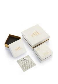 Vita smyckesförvaringslådor med guld detaljer, i olika storlekar, och en svart inredning. Inkluderar ett certifikatkort med skötselråd.