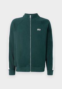 Dark green zip-up jacket with a high collar, white side stripes, and a small white logo on the chest, made from a soft fabric.