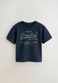 Tmavě modré bavlněné tričko s krátkými rukávy a kulatým výstřihem, s logem "SuperDry" v šedé a žluté barvě. Na levém rukávu je visačka.