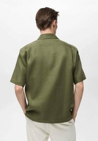 Short-sleeve olive green shirt made of lightweight fabric, featuring a classic collar and a relaxed fit with a straight hem.