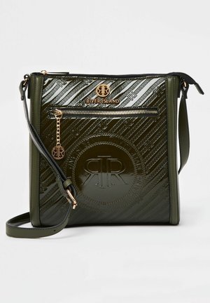 Ciemnozielona torebka na ramię z lakierowanej skóry, ozdobiona tłoczonymi wzorami logo, z przednią kieszenią na zamek z ozdobnym złotym łańcuszkiem oraz regulowanym paskiem.