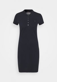 Navy polo-mekko, joka on valmistettu puuvillasta, lyhyt hiha, napit edessä ja suora leikkaus. Rinnassa logo-yksityiskohta.