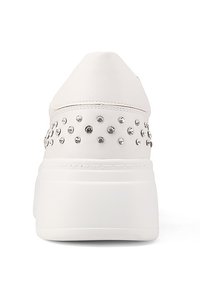 Sneaker bianco con punta arrotondata, texture liscia e borchie metalliche sul tallone posteriore. Presenta una suola bianca spessa per un'altezza aggiuntiva.