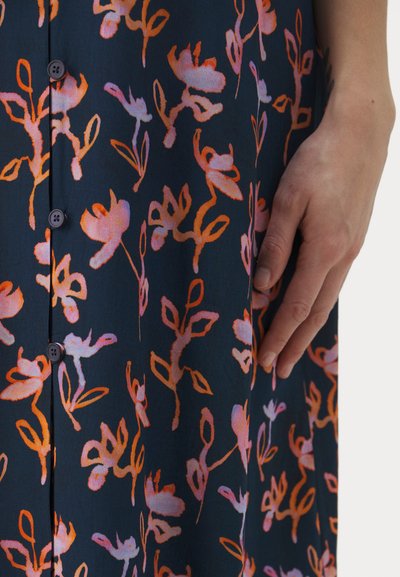 Mörkblå klänning av tyg med blommönster i nyanser av rosa och orange, med sex knappar framtill och en texturerad yta.
