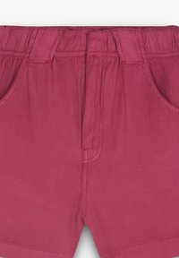 Bordeaux korte broek van een katoenmix; voorzien van een elastische tailleband, twee zijzakken en iets taps toelopende broekspijpen met stiksel-details.