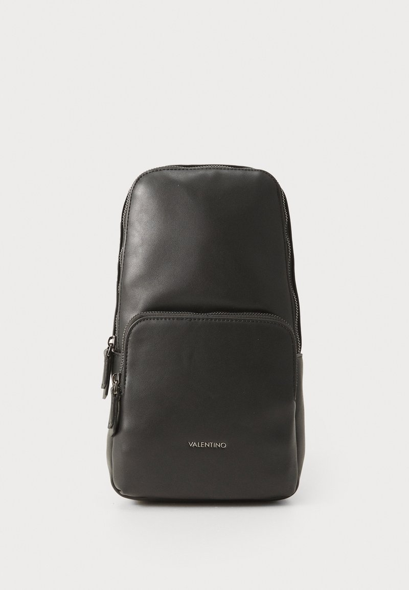 Zaino in pelle nera con una texture liscia, dotato di un tascone principale con zip e di una tasca frontale. Logo visibile sul davanti.