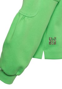 Groene top met lange mouwen, met geplooide pofmouwen, manchetten, een sluitzakdetail, een split aan de zijkant en een panterprint merklogo dichtbij de zoom.