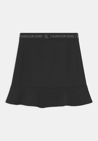 Saia preta em formato evasé, feita de um tecido elástico, com uma cintura preta que exibe a marca "CALVIN KLEIN JEANS". Textura suave, design minimalista.