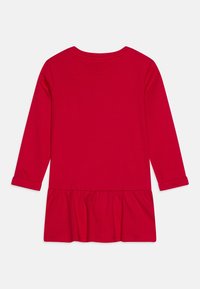 Czerwona sukienka z długim rękawem wykonana z miękkiej dzianiny dżersejowej, z talią zebrną dla rozkloszowanego dołu oraz podwiniętymi mankietami na rękawach.