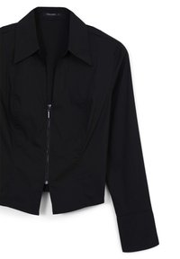 Schwarze, kurz geschnittene Jacke mit langen Ärmeln, Reverskragen und Frontreißverschluss. Hergestellt aus glattem Stoff mit subtiler Struktur und taillierter Passform.