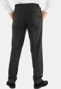 Donkergrijze broek met een fijne structuur, voorzien van twee achterzakken en een recht model, gecombineerd met zwarte schoenen.
