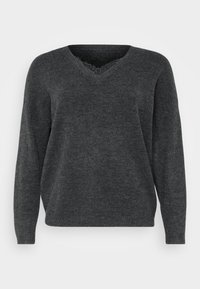 Grå v-ringad tröja med långa ärmar, med en mjuk textur och subtila fransdetaljer runt kragen. Avslappnad, ledig passform.