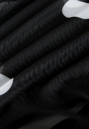 Schwarzer Stoff mit einer strukturierten Oberfläche und sichtbaren Falten, akzentuiert durch große weiße Polka-Dots. Das Material wirkt leicht und durchsichtig.