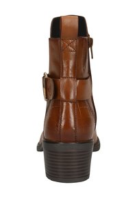 Brown leather ankle boot with a textured crocodile pattern, side zipper, and buckle detail. Features a stacked heel and smooth finish.