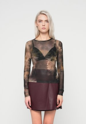 Langærmet mesh top med et brunt og sort tie-dye mønster, lagdelt over en sort bralette, parret med en burgunder læder mini-nederdel.