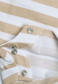 Bomuldsbodysuit med skiftende beige og hvide striber, med sølvfarvede trykknapper ved skulderen og en blød, glat tekstur.