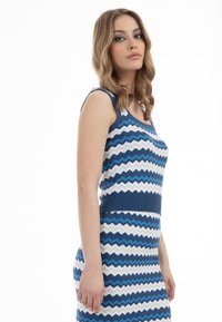 Abito in maglia con motivo zigzag blu e bianco, dal design aderente, scollo a barchetta e orlo a coste, realizzato in tessuto morbido ed elastico.