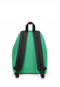 Mochila verde con una textura suave, correas ajustables negras y un asa en la parte superior. Presenta una forma redondeada y un diseño simple sin adornos.