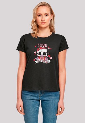 Schwarzes Kurzarm-T-Shirt mit einem Grafikdesign eines Schädels, der Herzen umfasst, sowie dem Text "LIEBE LIEGT IN DER LUFT" in Pink und Weiß.