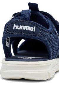 Navy mesh sandal with a white sole, featuring cutouts for breathability, a strap with logo detail, and a padded heel for comfort.