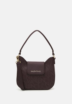 Sac à main Valentino marron foncé avec une poignée courte, une fermeture à rabat, un logo doré et un motif de lettres embossé subtil sur le corps.
