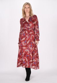 Langes rotes Kleid aus leichtem Stoff, mit einem Paisleymuster in Weiß und Blau, langen Ärmeln und einem V-Ausschnitt.