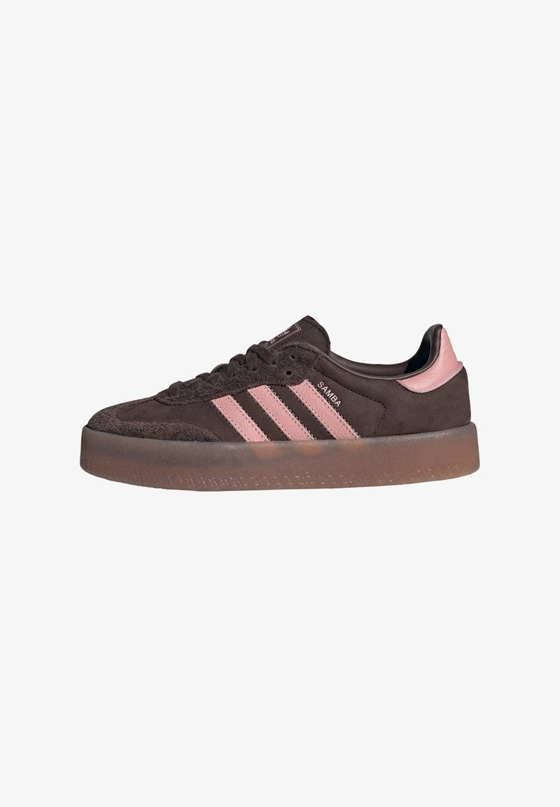 Barna velúr sneaker rózsaszín három csíkkal és sarkú díszítéssel. A kör alakú orr és a texturált gumitalp átlátszó élekkel rendelkezik.