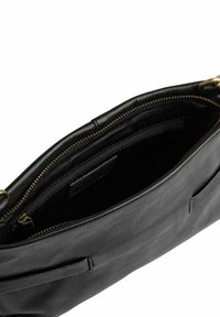 Svart läderhandväska med blixtlåsstängning. Insidan är klädd i svart tyg och har ytterligare fickor med blixtlås för att organisera.
