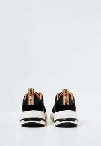 Černé tenisky s texturovaným zamšovým svrškem, oranžovými detaily na límci a bílou gumovou podrážkou. Na patě mají logo "Pepe Jeans".