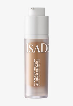 Flacon-pompe de fond de teint lumineux IsaDora Wake Up the Glow avec vitamine E, acide hyaluronique et SPF 50 en teinte beige moyen.